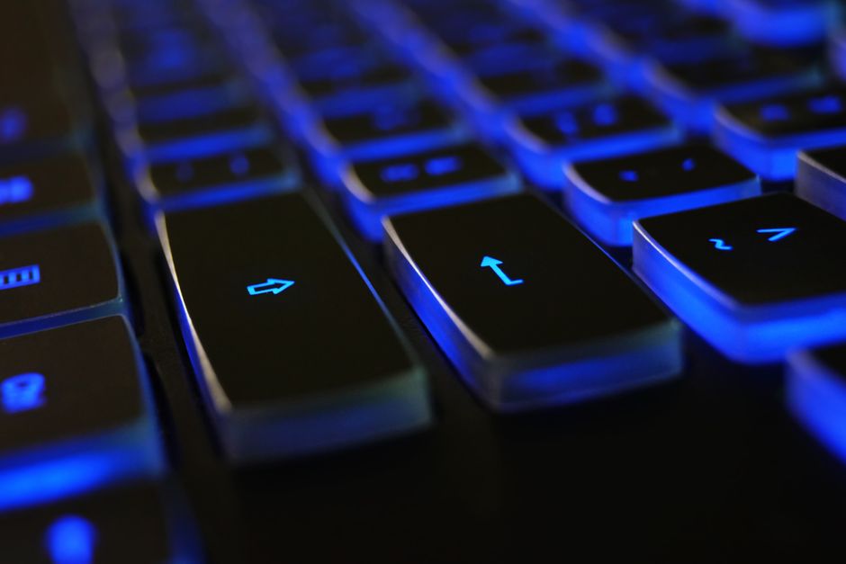 Imagem de teclado iluminado com luz azul, simbolizando tecnologia e inovação digital.