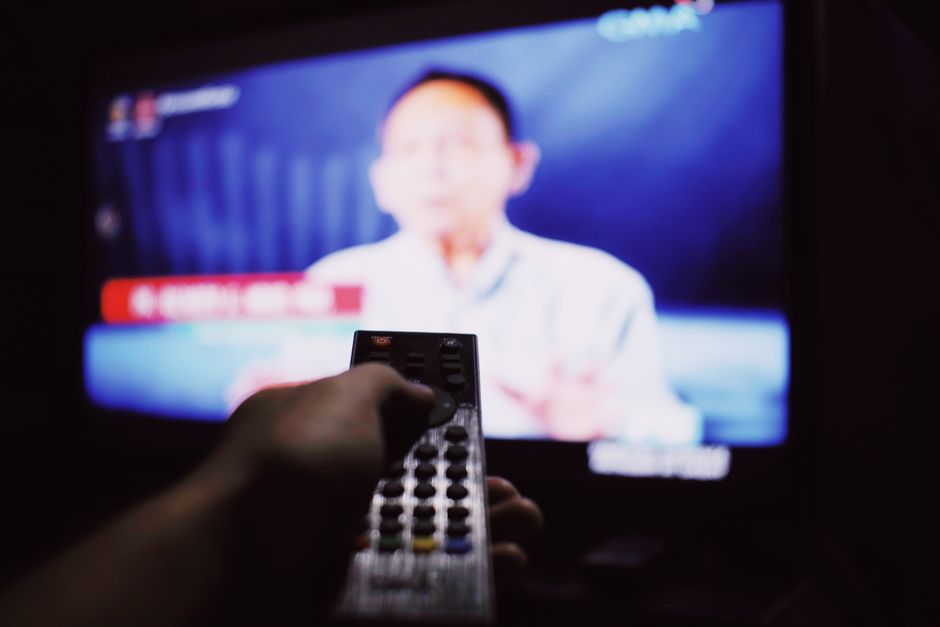 Pessoa assistindo a um programa de televisão em um ambiente de lazer