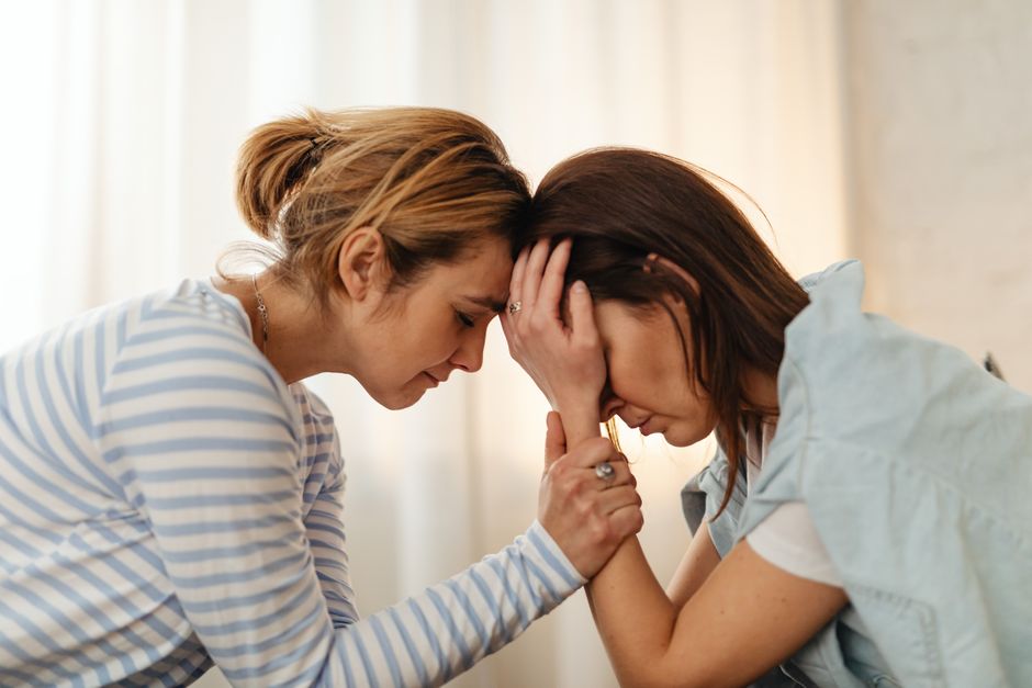 Duas mulheres envolvidas em um momento de emoção e apoio mútuo, simbolizando solidariedade e esperança.