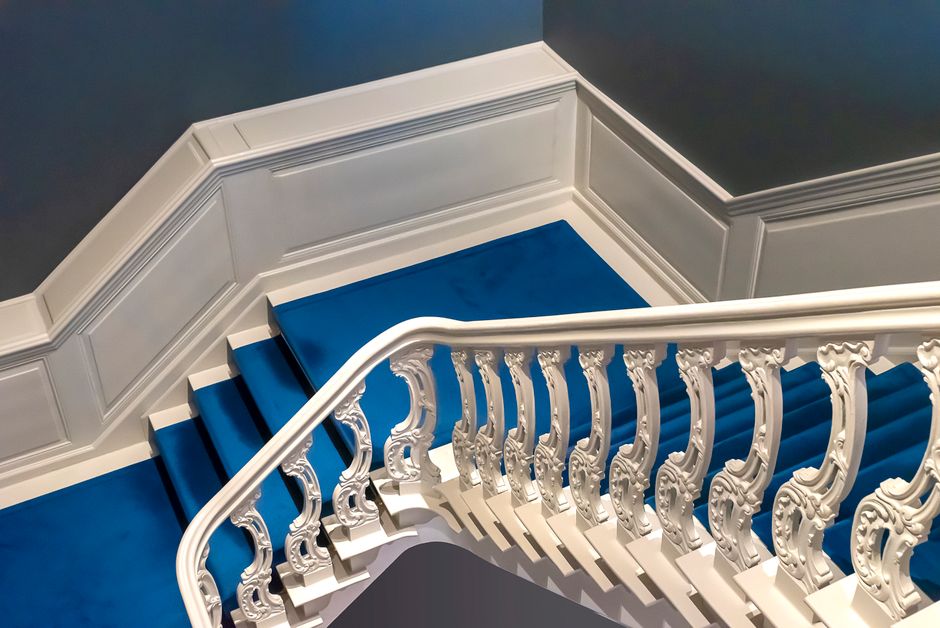 Escadaria elegante com detalhes decorativos em um interior sofisticado, destacando arquitetura clássica e design ergonômico.