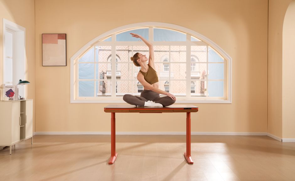 Mulher praticando yoga em ambiente interno com luz natural, focada no bem-estar e equilíbrio mental.