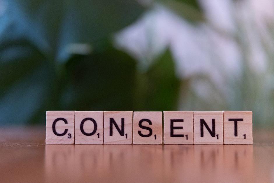 Imagem que representa a importância do consenso e cooperação em contextos de trabalho ou decisões coletivas, com blocos de letras formando a palavra 'CONSENT'.