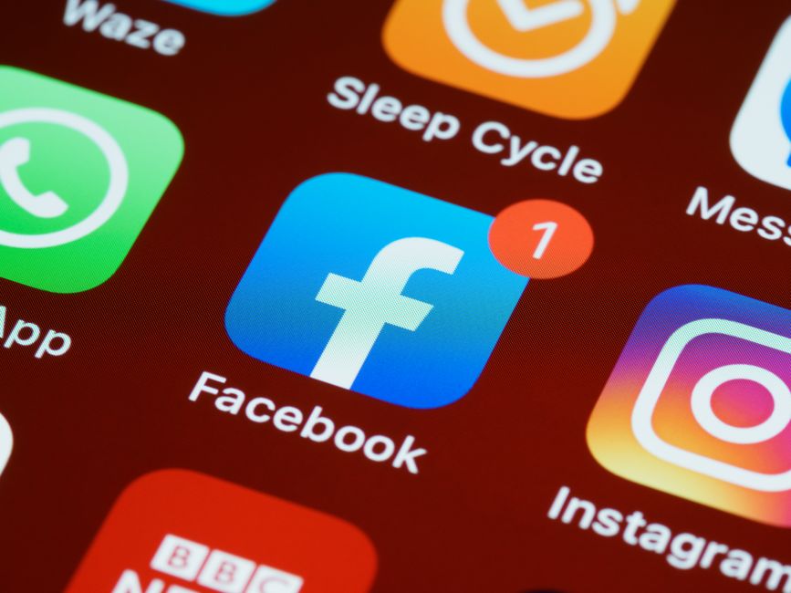 Imagem de um smartphone exibindo o aplicativo do Facebook com uma notificação, simbolizando redes sociais e comunicação digital.