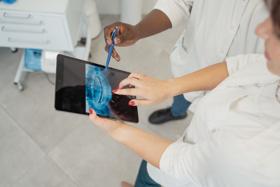 Profissionais de saúde utilizando uma tecnologia avançada para diagnóstico, representando inovação médica e tecnologia em saúde.