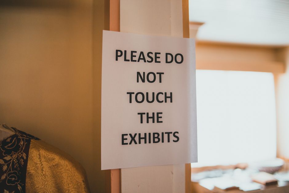 Aviso em uma exposição que orienta os visitantes a não tocarem nas peças em exibição.