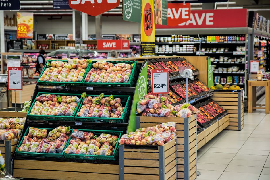Seção de frutas e legumes em supermercado, destacando a variedade e disposição dos hortifruti para compras de alimentos naturais.
