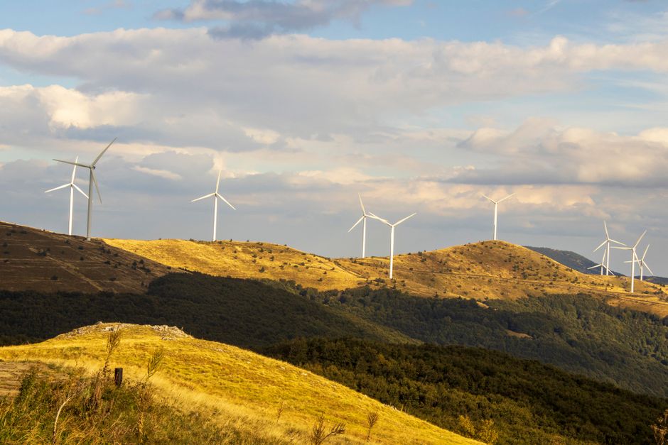 Paisagem de morros com parques eólicos, simbolizando energia renovável e sustentabilidade.
