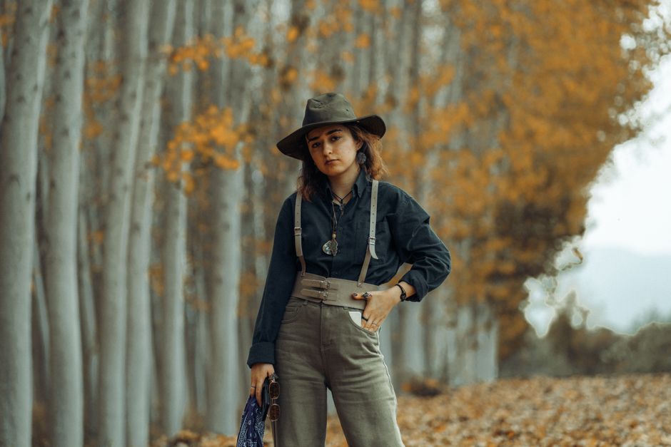 Mulher aventureira em ambiente natural de outono, destacando o tema de exploração e conexão com a natureza.