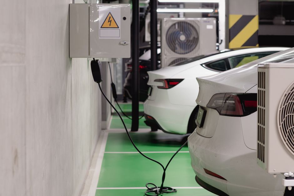 Imagem de carros elétricos estacionados em uma loja de recarga, destacando a temática de sustentabilidade e mobilidade elétrica.