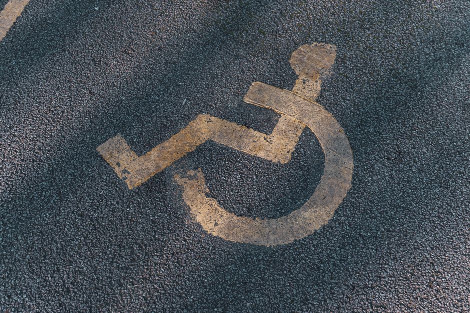 Imagem de símbolo de vaga para pessoas com deficiência pintado no solo de uma rua ou estacionamento, representando acessibilidade e inclusão.