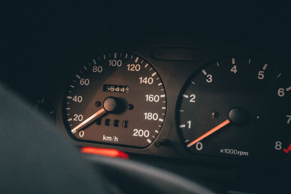 Painel de instrumentos de um carro, destacando velocidade e rotações do motor, representando temas de transporte e velocidade.