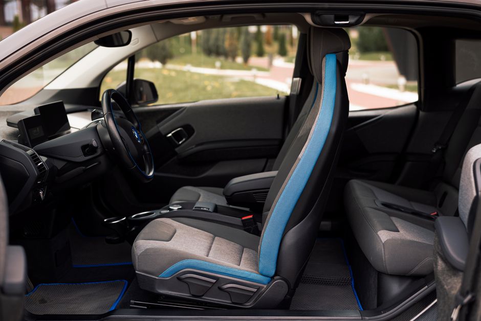 Interior de carro elétrico com assentos de design moderno, ressaltando a inovação e sustentabilidade no transporte pessoal.