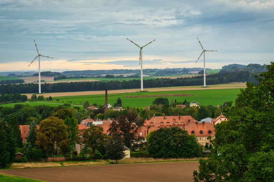 Paisagem rural com painéis de turbinas eólicas simbolizando energia renovável e sustentabilidade.