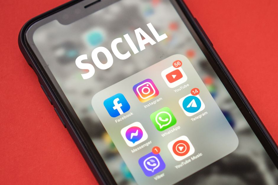 Imagem de um smartphone com ícones de redes sociais, representando o impacto das plataformas digitais na comunicação atual.