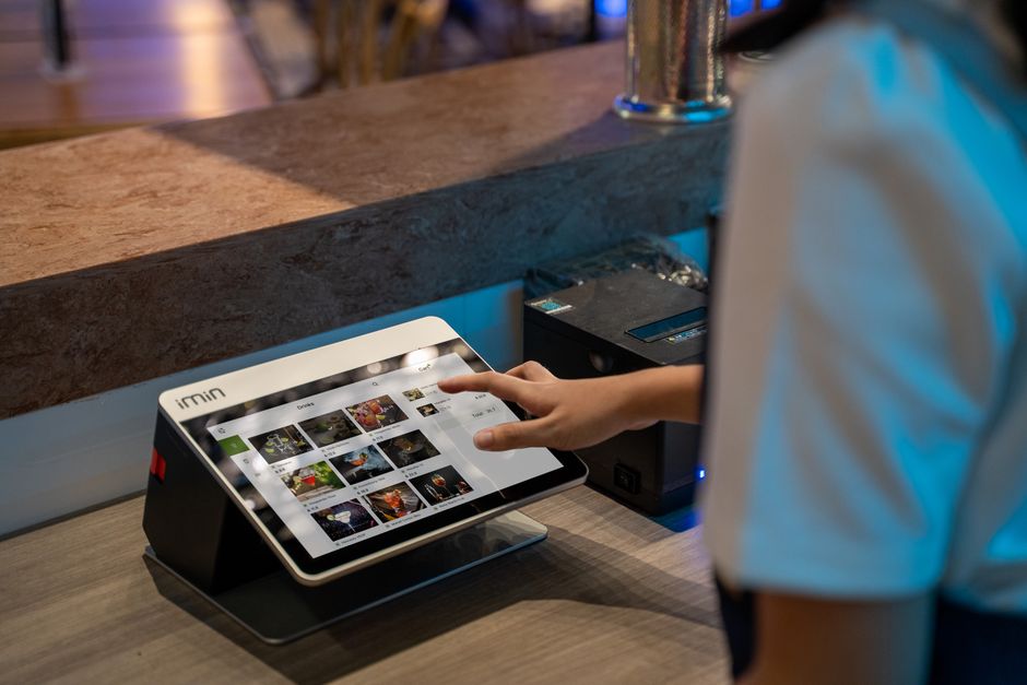 Pessoa usando um tablet para gerenciar fotos ou conteúdo digital em um ambiente de negócios ou lazer.