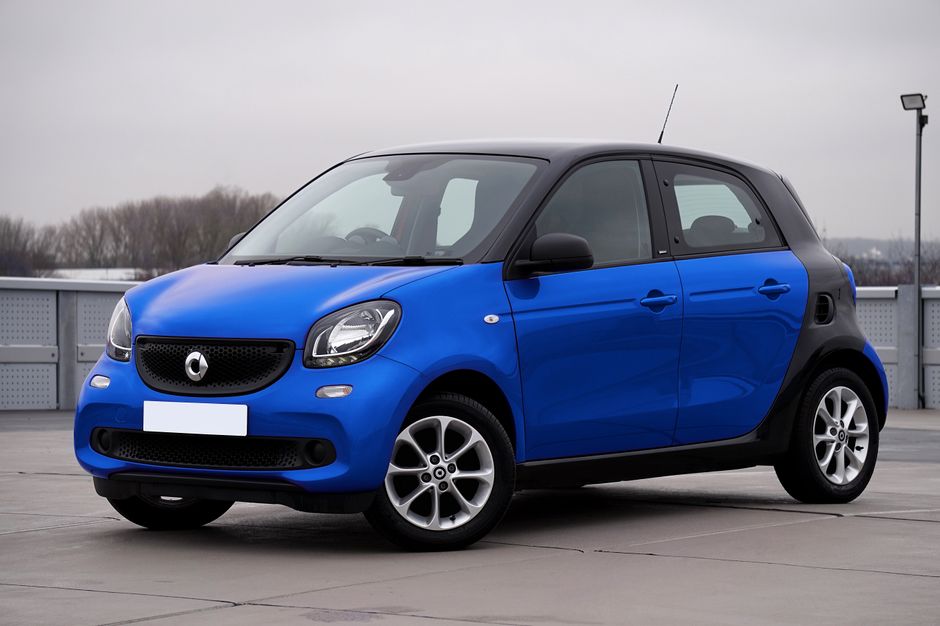 Carro elétrico compacto azul estacionado em um estacionamento, representando inovação e mobilidade sustentável.