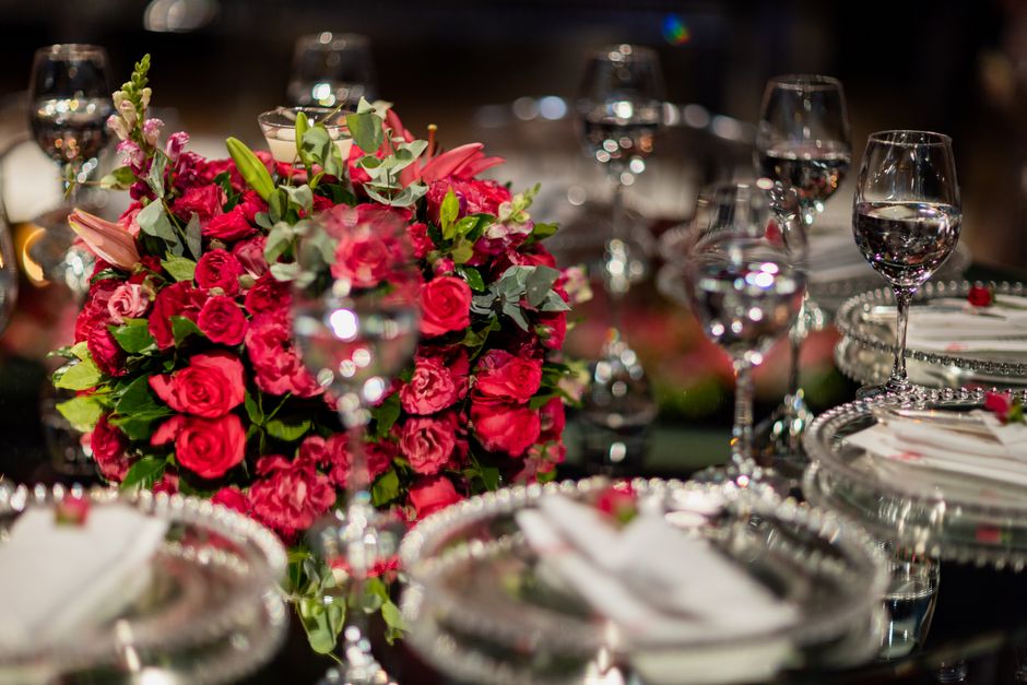 Imagem de uma mesa elegantemente decorada com um arranjo vibrante de flores rosadas como centro de uma ocasião especial ou celebração.