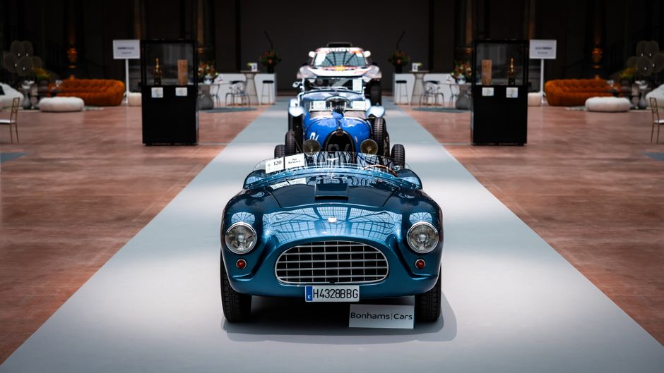 Exposição de carros clássicos em um evento de automóveis de luxo, destacando a elegância e o design vintage.