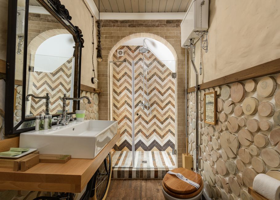 Banheiro decorado com estilo rústico e detalhes em mosaico, combinando elementos naturais e modernos.