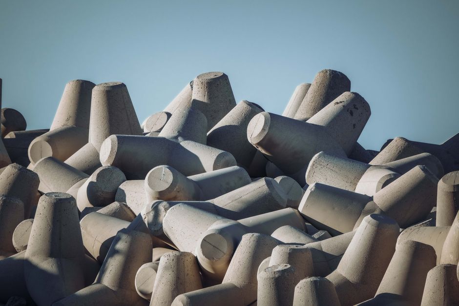 Imagem de grandes blocos de concreto empilhados, frequentemente utilizados na construção civil.