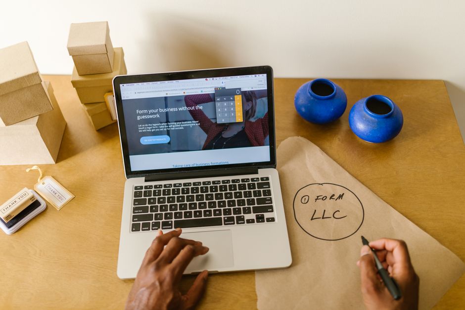 Imagem de uma mesa de trabalho com laptop, papéis, caixas de presente e vasos decorativos, ideal para um artigo sobre empreendedorismo e gestão de negócios.