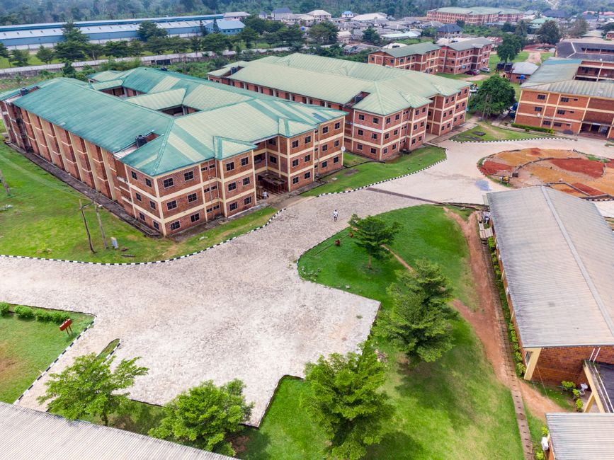 Imagem aérea de um complexo universitário com edifícios de cinco andares e áreas verdes, representando o ambiente de ensino e aprendizagem.
