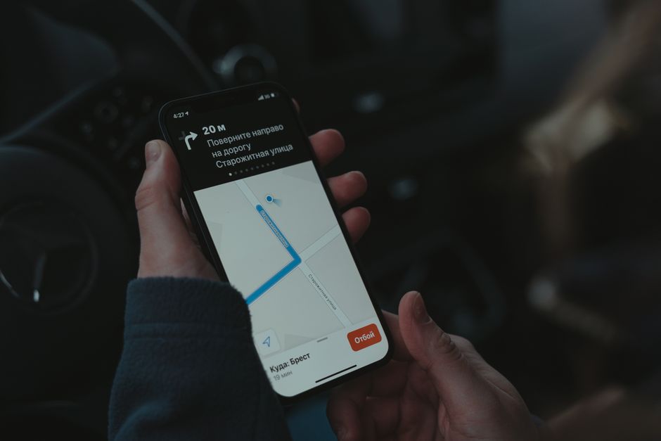 Pessoa navegando por um aplicativo de mapas no celular enquanto dirige, planejando o trajeto para um destino chamado Brest.