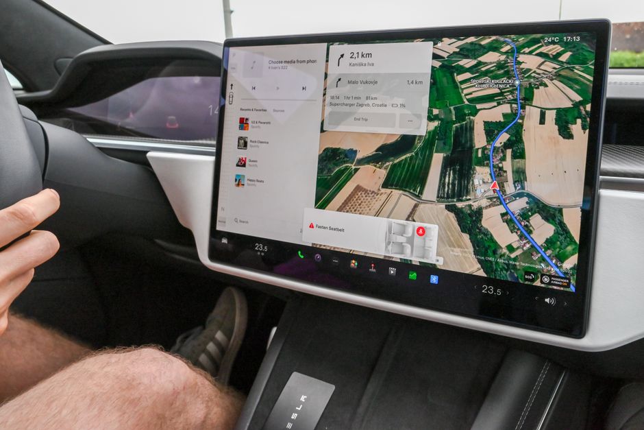 Painel digital de um carro elétrico exibindo navegação e informações de viagem, destacando tecnologia automotiva moderna.