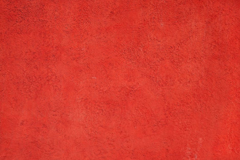 Parede vermelha com textura rústica, ideal para fundo de blog sobre design de interiores ou decoração.