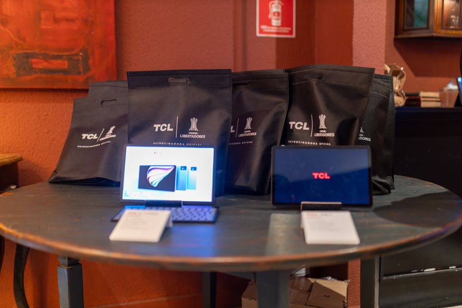 Imagem de um display digital e sacolas promocionais de uma marca de eletrônicos, destacando a estratégia de marketing de branding em um espaço de varejo.