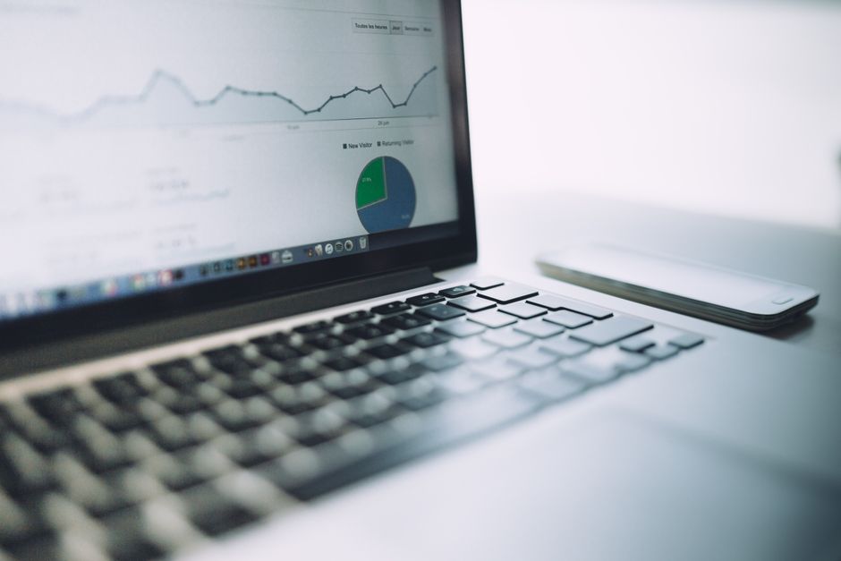 Imagem de um notebook exibindo gráficos e dados financeiros, relacionada à análise de dados e tomada de decisão empresarial.
