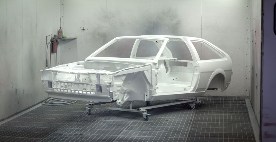Estrutura de carro em uma linha de produção ou oficina de montagem, representando o processo de fabricação automotiva.