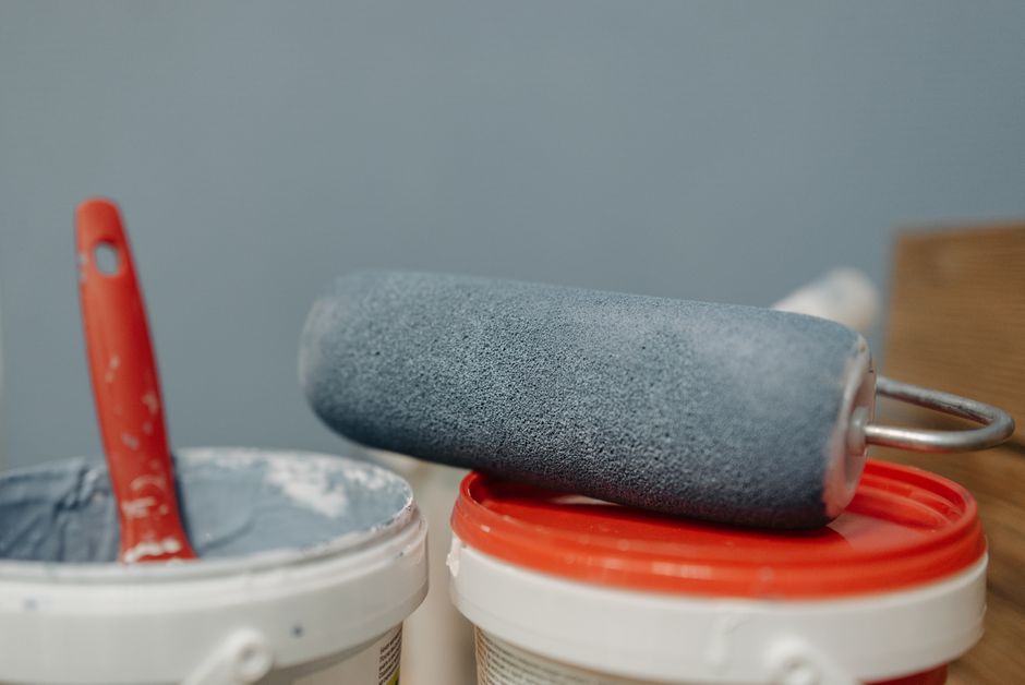 Imagem de ferramentas de pintura, incluindo rolo e lata de tinta, sugerindo melhorias ou reformas no ambiente.