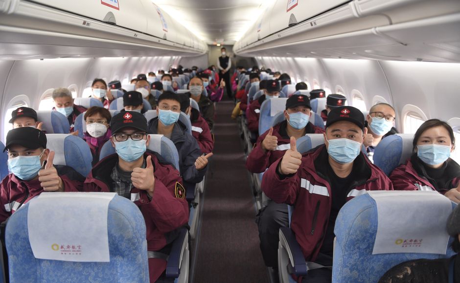 Grupo de profissionais de enfermagem viajando de avião,Todos usando máscaras faciais em uma viagem corporativa ou de treinamento.