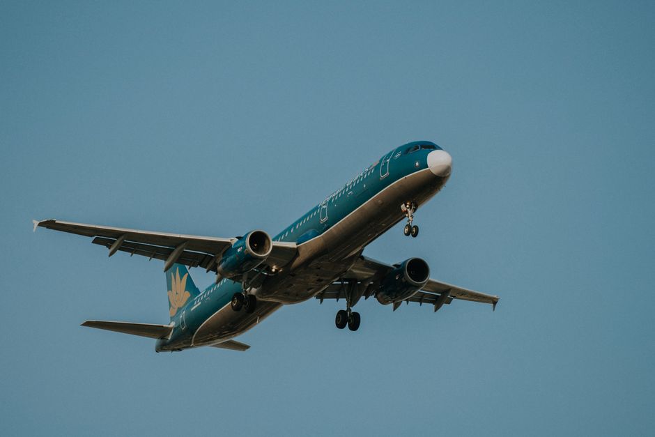 Avião comercial em voo, simbolizando transporte aéreo ou viagens de negócios.