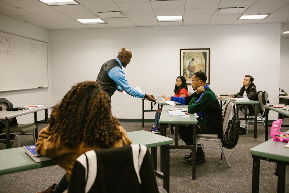Professor ensinando uma turma de estudantes em uma sala de aula moderna para um artigo sobre educação e ensino de adultos.