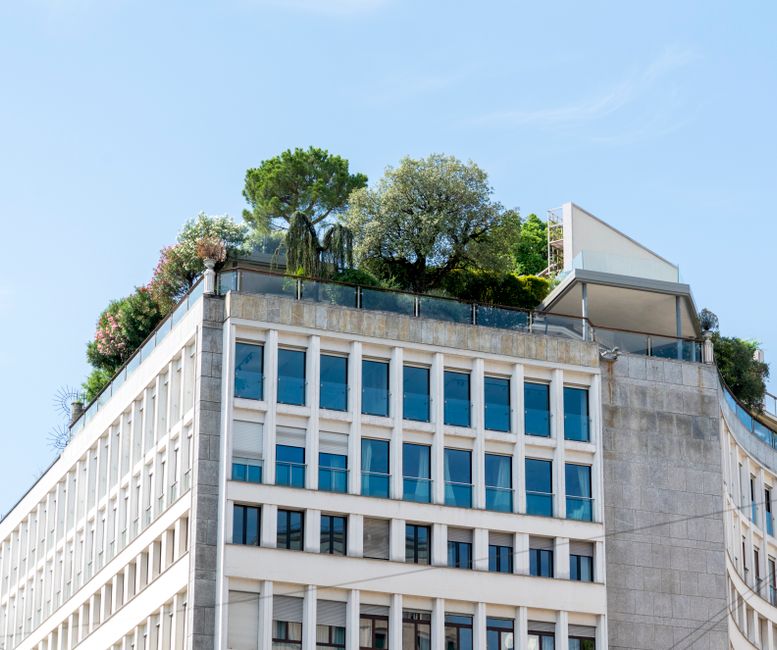 Imagem de um edifício moderno com área verde no topo, simbolizando sustentabilidade e arquitetura contemporânea.