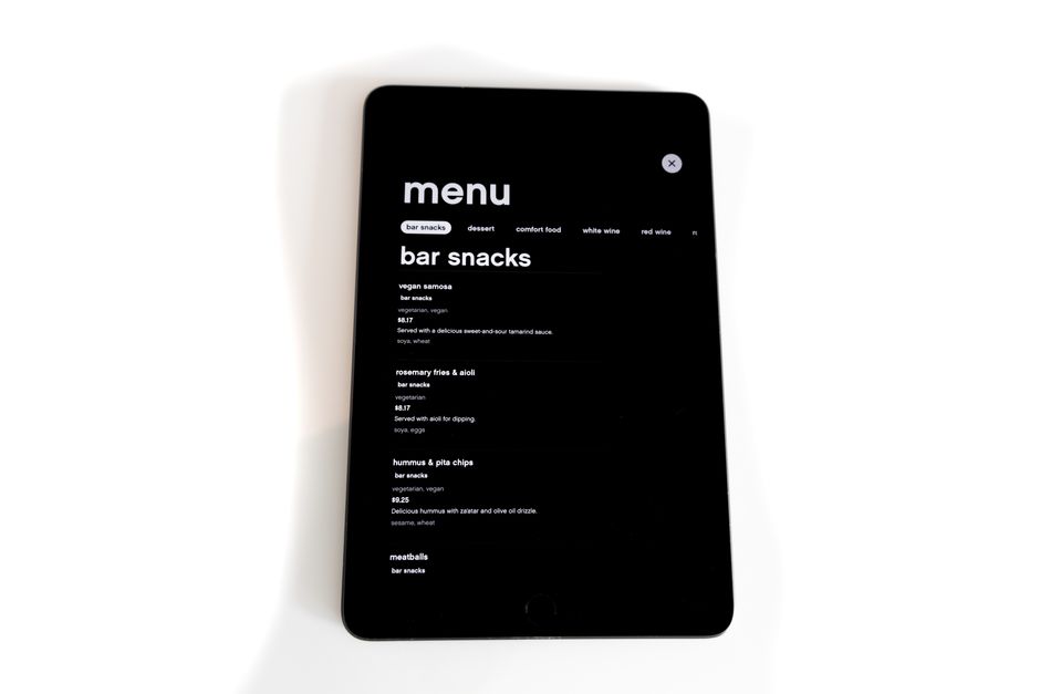 Imagem de um dispositivo digital exibindo um menu de opções de lanchonete, representando tecnologia na administração de negócios de alimentação.