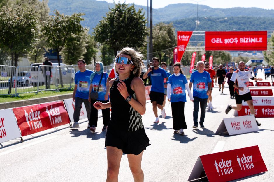 Mulher sorridente participando de uma corrida ao ar livre, simbolizando saúde, esportes ou eventos de bem-estar.