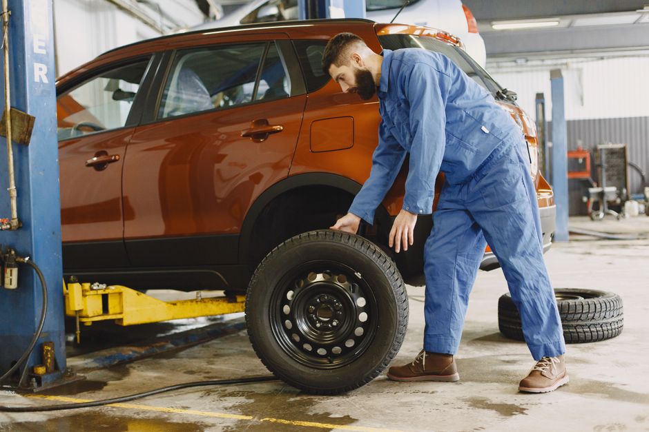 Mecânico realizando manutenção em um veículo SUV na oficina automotiva, destacando cuidados e reparos em carros.