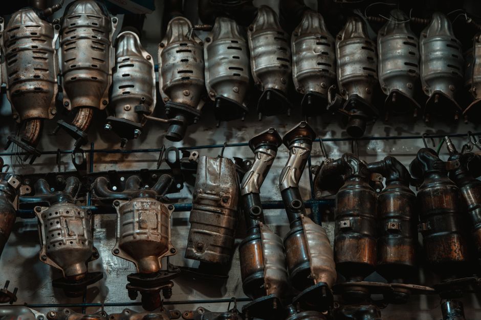 Exposição de peças de escapamento de carros em uma loja de autopeças ou oficina mecânica, destacando componentes automotivos de metal.