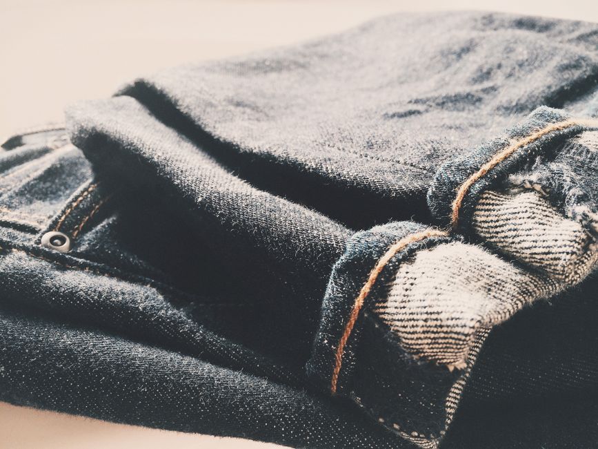 Imagem de um par de jeans sujos de areia, sugerindo uso ao ar livre e estilo casual para blog sobre moda e estilo de vida.