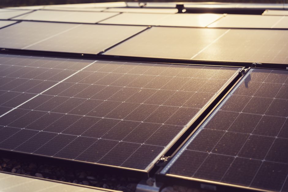 Imagem de painéis solares em um campo, com foco na geração de energia sustentável e renovável.
