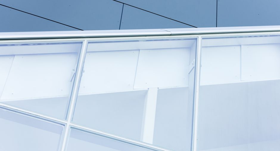 Imagem de uma fachada moderna de edifício com grande quantidade de vidro e estrutura metálica, ilustrando inovação e arquitetura contemporânea.