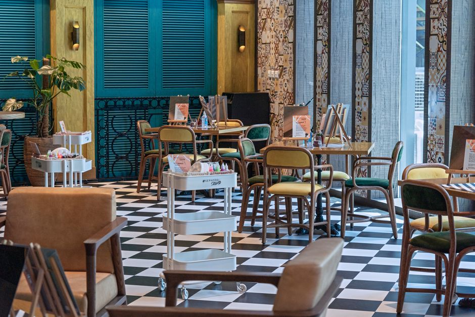Ambiente de coworking ou espaço de coworking com decoração moderna e mesas organizadas para trabalho colaborativo.
