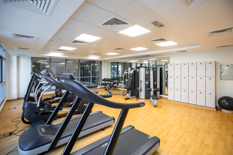 Sala de academia moderna com equipamentos de cardio e musculação acolhedora para alimentação de um blog sobre saúde e bem-estar.