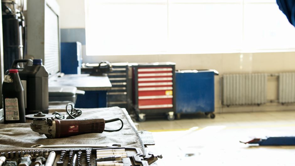 Ambiente de oficina ou oficina técnica com ferramentas e equipamentos de trabalho ao redor de janelas que iluminam o espaço naturalemente.