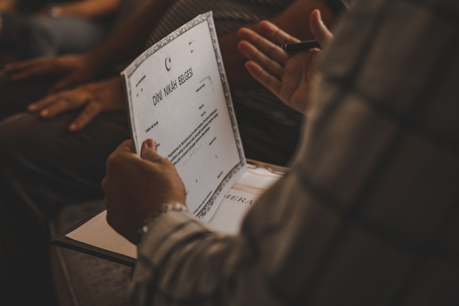 Pessoa recebendo uma certidão de casamento, simbolizando união e celebração de um momento importante de vida.