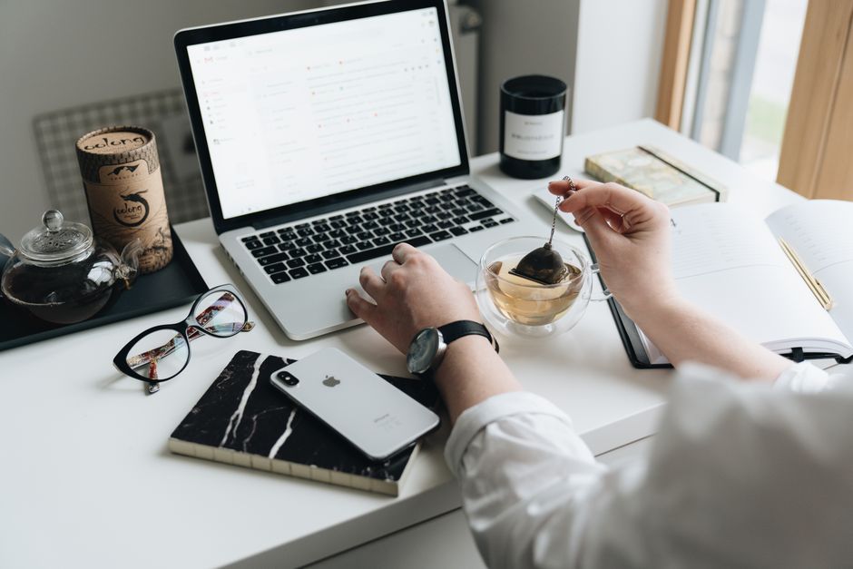 Pessoa trabalhando em ambiente de escritório, utilizando laptop e itens de organização, com foco em produtividade e rotina de trabalho remoto.