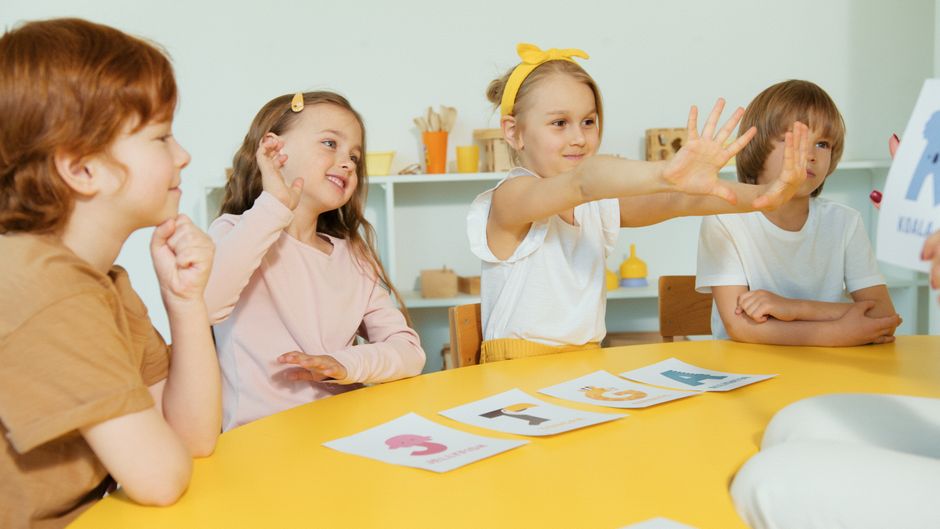 Crianças participando de uma atividade educativa em sala de aula, interagindo e aprendendo juntas.